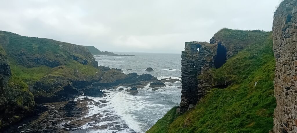 a castle falling off a cliff into the sea